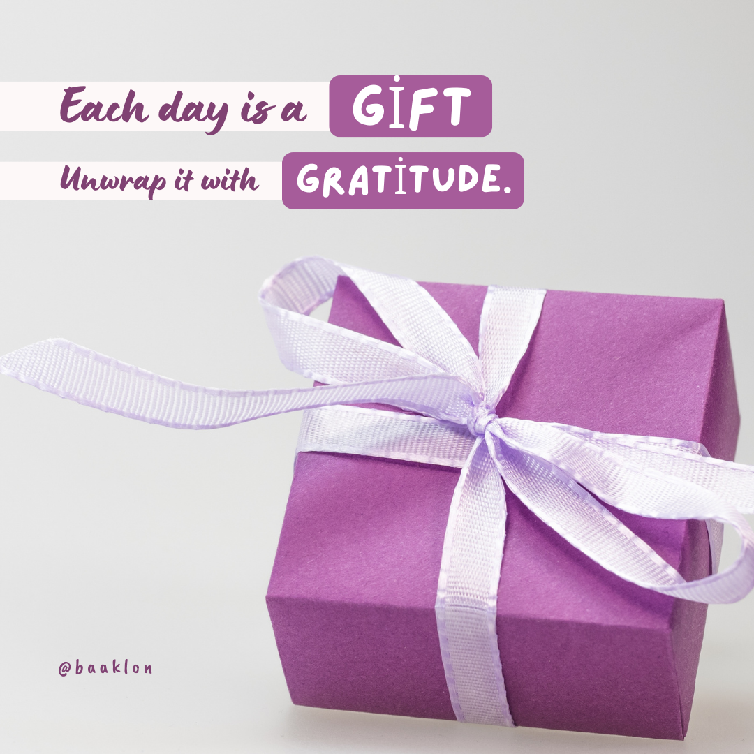 A purple gift card with a purple ribbon and a message that reads 'Each day is a gift. Unwrap it with gratitude.'